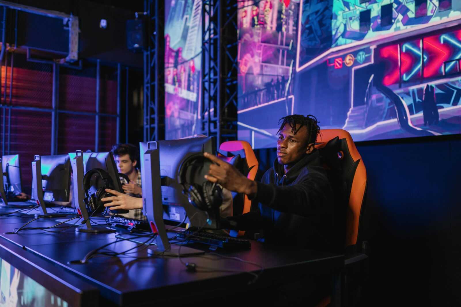 Two gamers intensely focused in a professional eSports competition with vibrant game visuals.